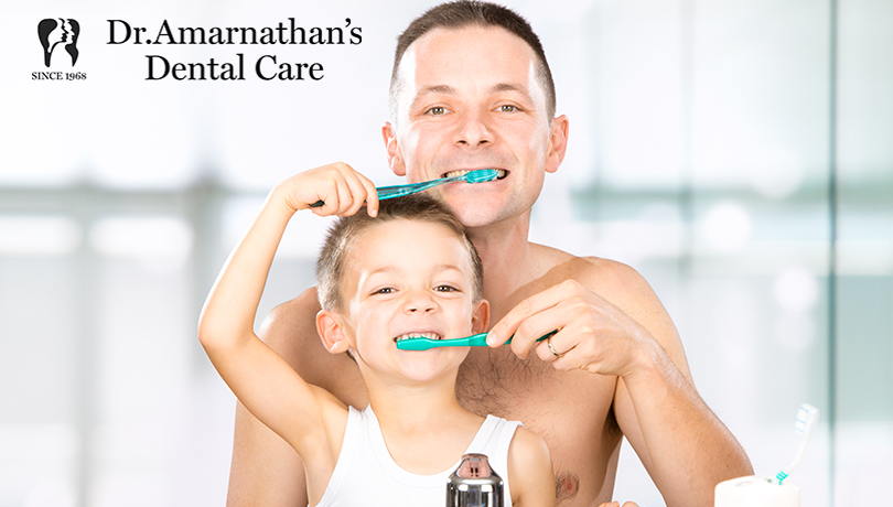happy son and father brushing teeth